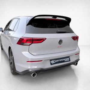 A-525_2jpg - OPSHOLDERS Rear view of a silver Volkswagen GTI wagon with a large rear spoiler and red taillights.