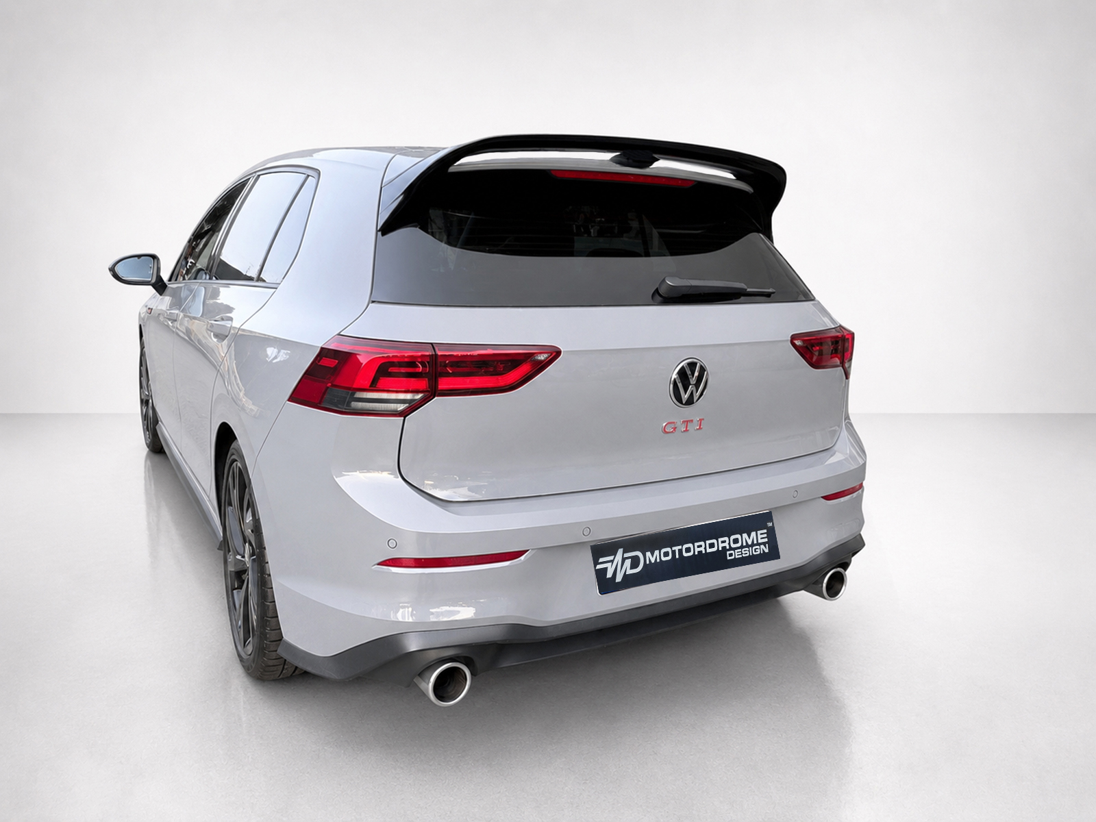 A-525_2jpg - OPSHOLDERS Rear view of a silver Volkswagen GTI wagon with a large rear spoiler and red taillights.