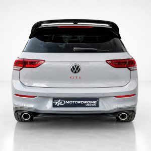A-525_3jpg - OPSHOLDERS Rear view of a silver Volkswagen GTI hatchback with a Motordrome Design plate and dual exhausts, visible in a studio setting.