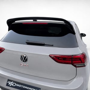 A-525_5jpg - OPSHOLDERS Rear view of a silver Volkswagen GTI hatchback in a studio, featuring a large black spoiler and red taillights.