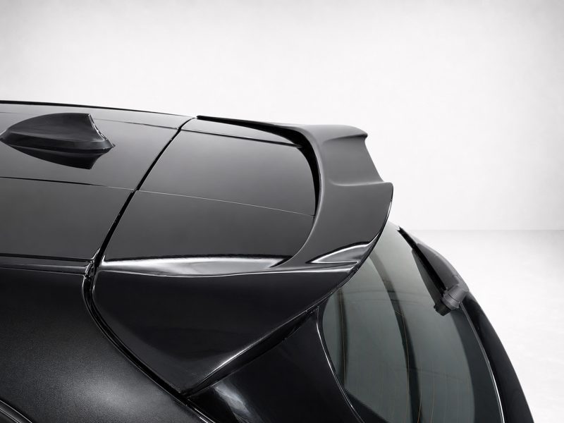 Close-up of a black sports car's rear spoiler and glossy roofline.