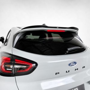 Rear three-quarter view of a white Ford Puma, showing taillights, rear wiper, and roof spoiler (car model and branding visible).