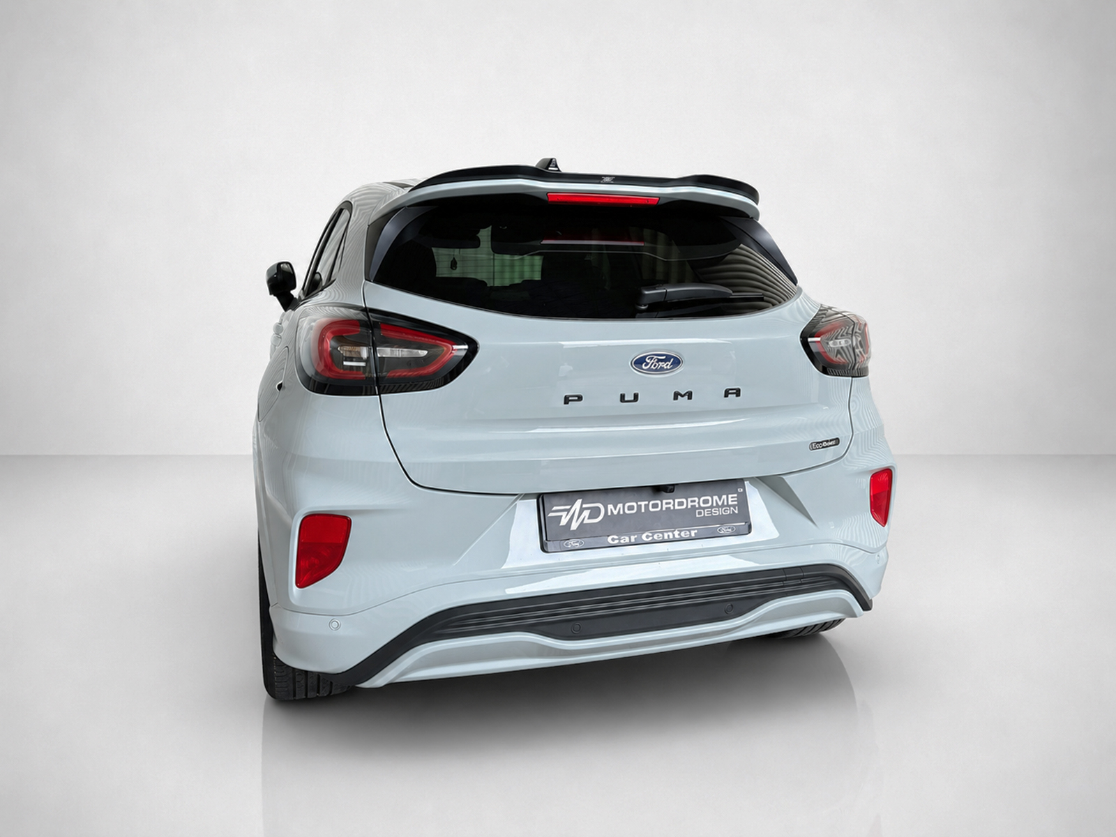 A-531_2jpg - OPSHOLDERS Rear view of a light blue Ford Puma SUV in a studio setting, showing taillights, Ford badge, and rear bumper detail.