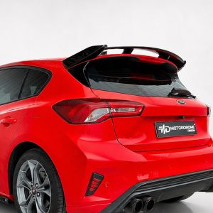 Red hatchback car rear view with a large spoiler and dual exhausts on a light background