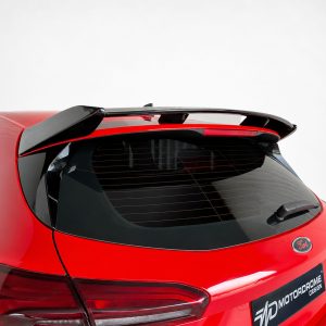Red Ford hatchback rear with a black roof spoiler and defogger lines on the rear window.