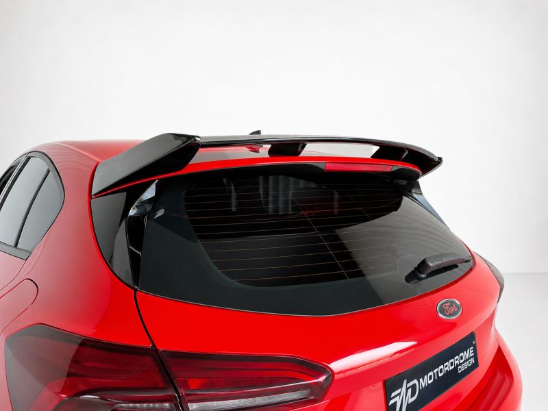 Red Ford hatchback rear with a black roof spoiler and defogger lines on the rear window.