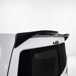 Back corner of a white SUV showing a black roof spoiler against a light backdrop