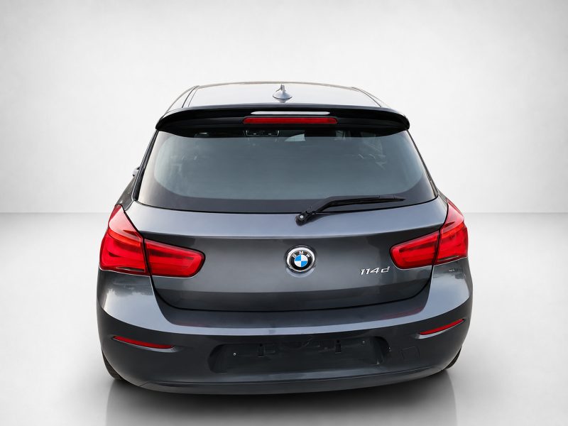 Rear view of a gray BMW SUV featuring red taillights, rear windshield wiper, and roof rails.
