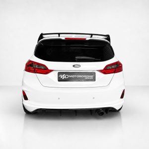 A-535_3jpg - OPSHOLDERS Rear view of a white Ford hatchback with red taillights and a Motordrome Design license plate.
