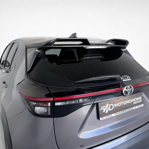 Rear view of a gray SUV with a roof spoiler, taillights, and a branded license plate area reading MOTORDROME DESIGN.