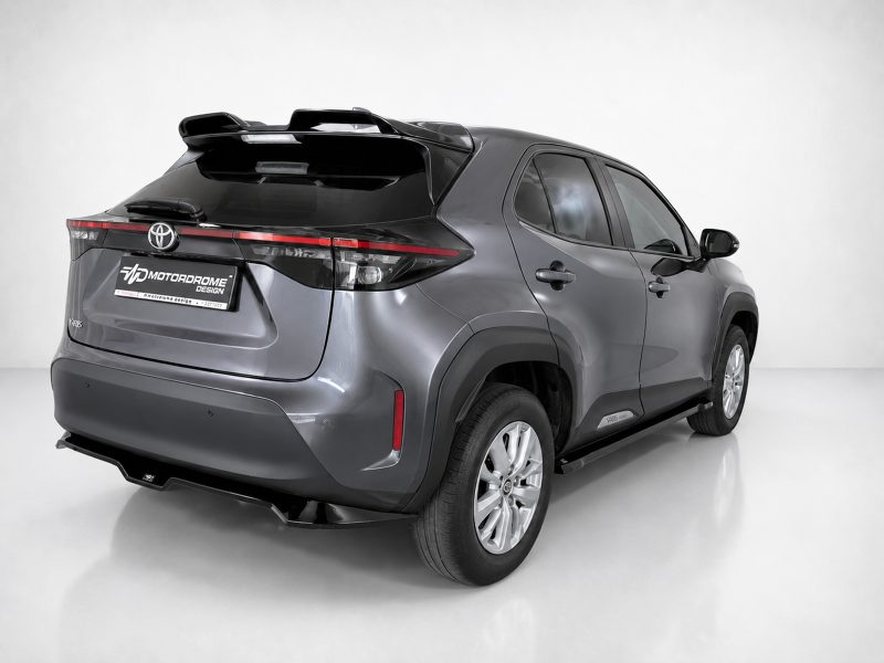A-536_4jpg - OPSHOLDERS Gray Toyota RAV4 SUV viewed from the rear three-quarter angle, showing the roof spoiler, sleek taillights, and large alloy wheels in a bright studio setting.