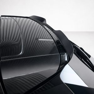 A-537_4jpg - OPSHOLDERS Close-up of a glossy black car with curved panels and a windshield wiper resting on the glass, highlighting reflections and sleek design.