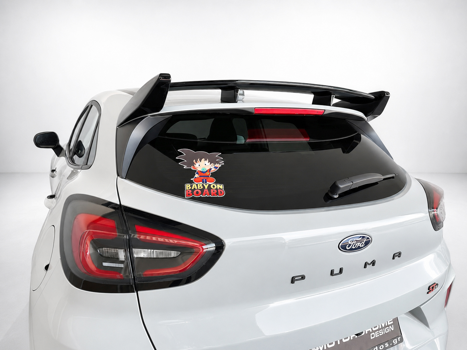 A-538_1jpg - OPSHOLDERS White Ford SUV rear with a 'Baby on Board' sticker on the rear window and a spoiler visible under a clean car design