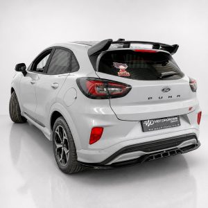 A-538_2jpg - OPSHOLDERS Rear three-quarter view of a white Ford Puma ST hatchback in a studio setting with a spoiler and sporty wheels on display