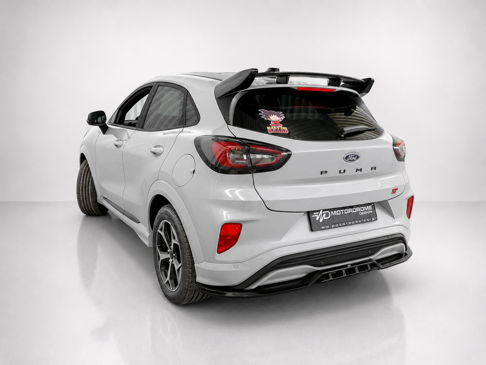 A-538_2jpg - OPSHOLDERS Rear three-quarter view of a white Ford Puma ST hatchback in a studio setting with a spoiler and sporty wheels on display