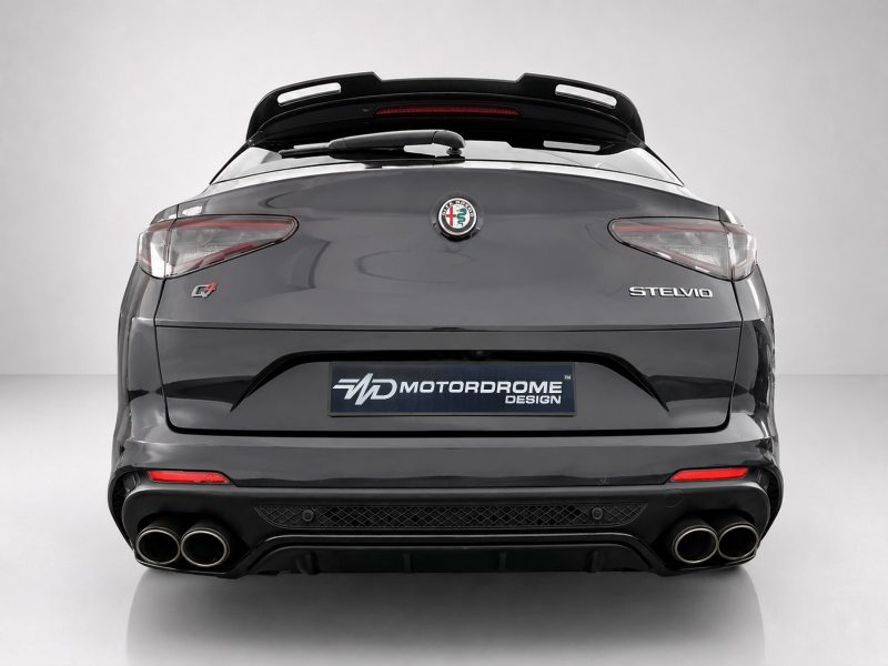 Rear view of a gray Alfa Romeo Stelvio with quad exhausts, spoiler, and MotorDrome Design plate visible on the bumper size.