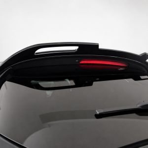 Rear spoiler with integrated red brake light on top of a dark car hatchback