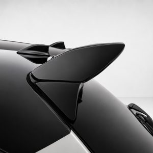 A-541_5jpg - OPSHOLDERS Close-up of a glossy black car spoiler on a sleek vehicle, highlighting its aerodynamic shape and reflections.