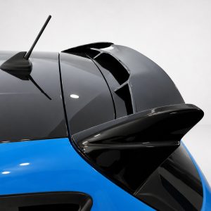 A-542_4jpg - OPSHOLDERS Close-up of a blue car's rear section showing a black spoiler and roof antenna and a light backdrop.