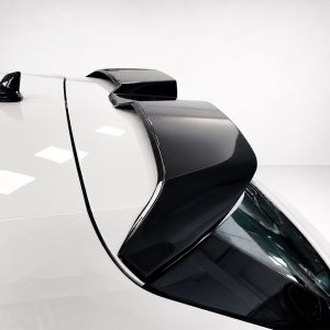 Close-up of a white car roof with a glossy black rear spoiler and antennae.