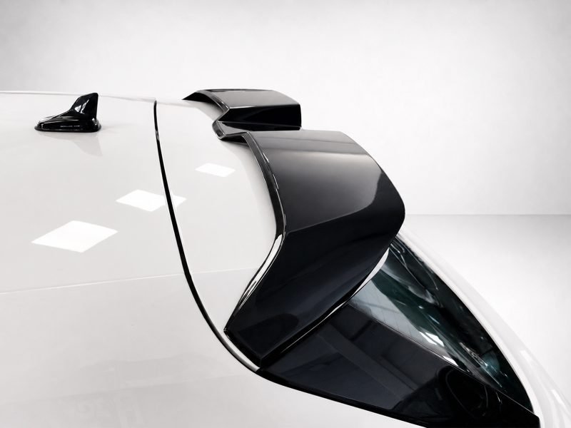 Close-up of a white car roof with a glossy black rear spoiler and antennae.