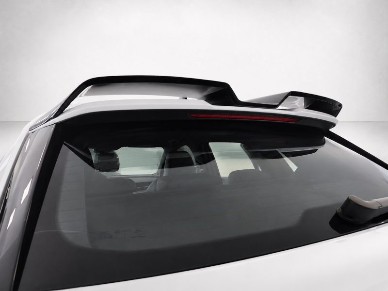 Rear view of a white SUV with a black roof spoiler and a red high-mounted brake light bar