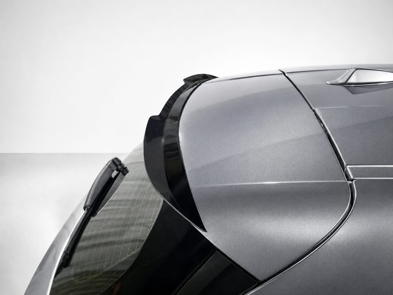 A-546_3jpg - OPSHOLDERS Close-up of a silver car's rear roofline and spoiler with curved panels and glossy finish.