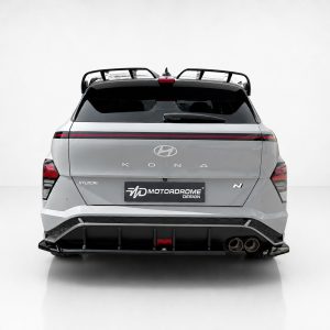 Rear view of a silver Hyundai Kona N with a red taillight strip and roof rack on a light background.