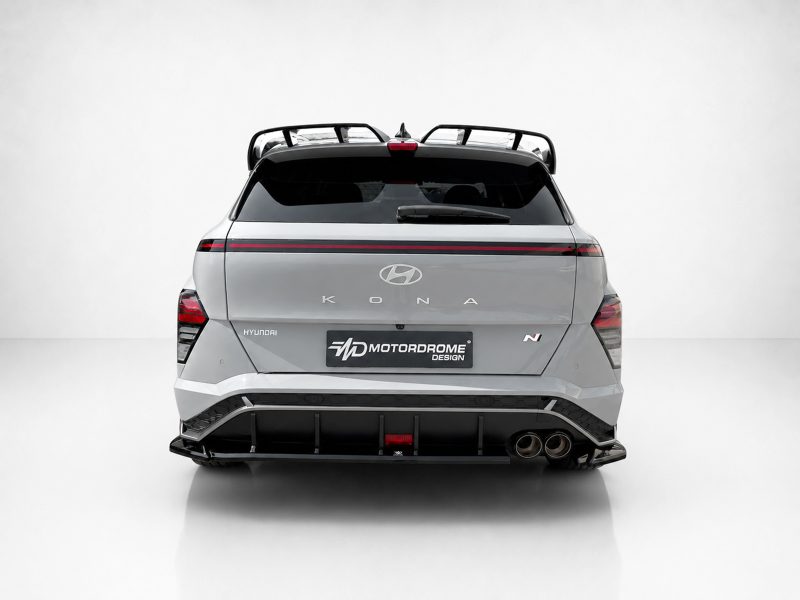 Rear view of a silver Hyundai Kona N with a red taillight strip and roof rack on a light background.