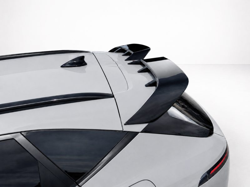 White sports car rear with a large black spoiler and dark-tinted windows.