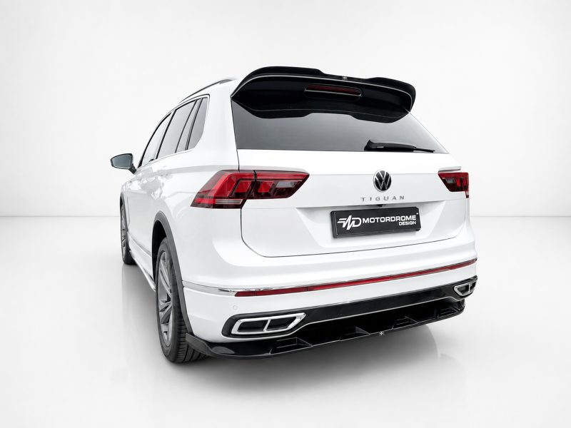 Rear view of a white Volkswagen Tiguan SUV in a studio setting, showing the taillights, rear window, and spoiler.