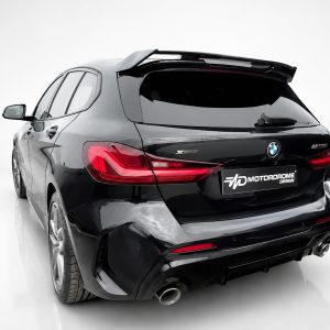 Black BMW SUV rear view with custom Motordrome Design plate and sporty spoiler, in a clean studio setting.