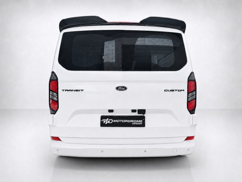 A-550_3jpg - OPSHOLDERS Rear view of a white Ford Transit Custom van with Ford emblem, badge text, and a Motordrome Design plate on a neutral background