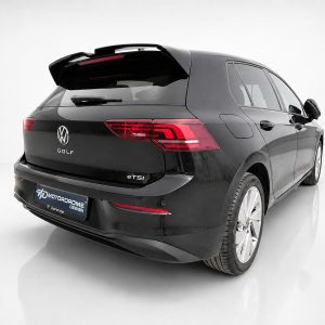 Rear three-quarter view of a black Volkswagen Golf eTSI hatchback in a white studio. It shows the taillights, rear spoiler, and back bumper.