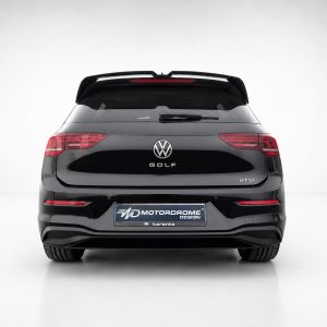 Rear view of a black Volkswagen Golf eTSI in a studio setting with a Motordrome Design plate on the bumper