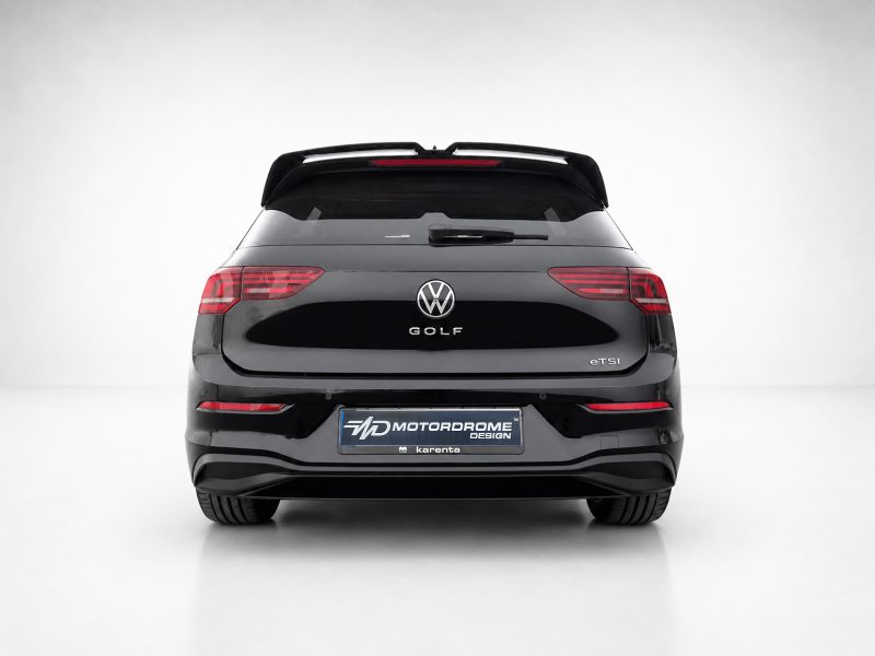 Rear view of a black Volkswagen Golf eTSI in a studio setting with a Motordrome Design plate on the bumper