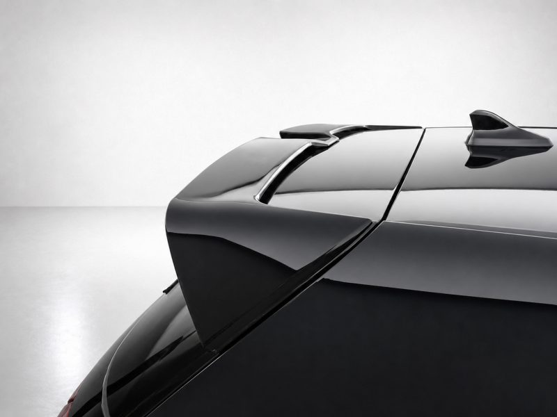 Rear view of a sleek black car showing a spoiler and glossy finish against a light background.
