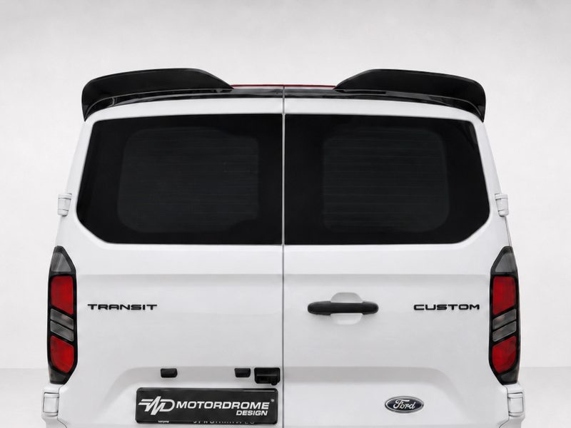 Rear view of a white Ford Transit Custom van with dark rear windows and a spoiler above the back doors.