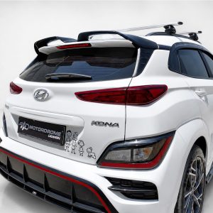 White Hyundai Kona SUV rear three-quarter view with roof racks and red accents; tailgate shows a Motordome Design sticker and cartoon drawings