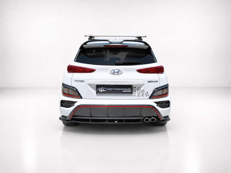 Rear view of a white Hyundai Kona with a roof rack and red-accented bumper diffuser, featuring a Motordrome Design plate and small cartoon decals on the bumper area.