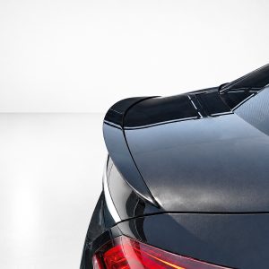 Close-up of a dark, glossy car rear with a red taillight.