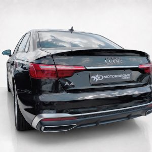 A-556_2jpg - OPSHOLDERS Rear view of a black Audi A4 in a studio setting with visible logo and taillights, plate readable as MOTORDROME DESIGN.