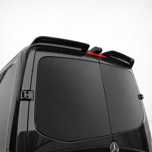 Rear-right view of a black Mercedes-Benz van with a roof spoiler and dark tinted windows, red brake light visible on top edge.