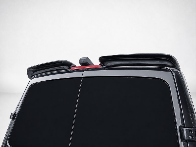 Rear view of a glossy black SUV with raised roof rails and a slim red third brake light between them