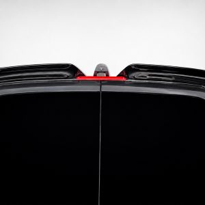 Rear view of a black SUV, showing a roof-mounted spoiler and a red center brake light between the spoilers.
