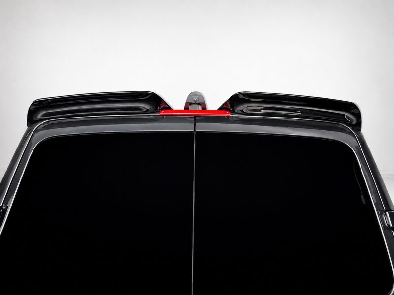 Rear view of a black SUV, showing a roof-mounted spoiler and a red center brake light between the spoilers.
