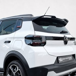 Rear-left view of a white SUV showing black roof spoiler, glossy taillights, and Citroën badge on the tailgate.