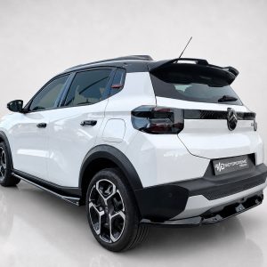 Rear three-quarter view of a white compact SUV with a black roof, showing sporty alloy wheels and Motordrome Design badge on the tailgate.