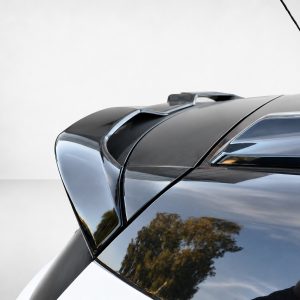 Close-up of the roof and rear area of a glossy dark car, featuring a raised spoiler and an antenna on the roofline.