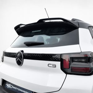 Rear view of a white SUV with a black roof spoiler, showing a 'C3' badge on the tailgate and dark taillights in a studio setting.